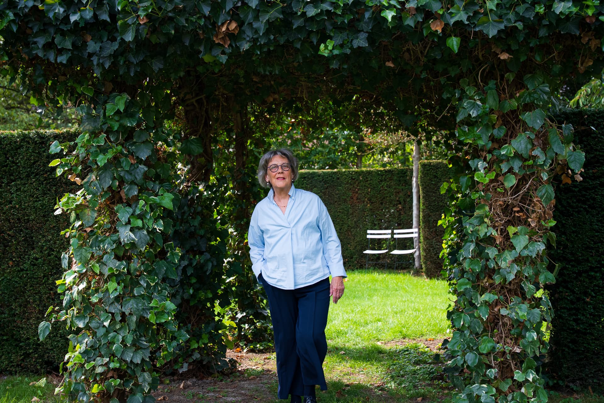 Portret van Marlène Dehing, executive coach in Limburg, onder een groene tuinboog